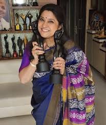 Renuka Shahane holding her Filmfare OTT Award trophies