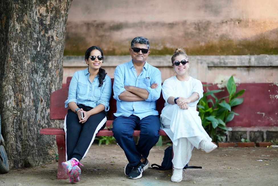 A Bombay Film Cartel producer smiling on set beside the camera crew